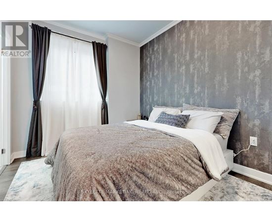 A bedroom with a large bed and a window with curtains.