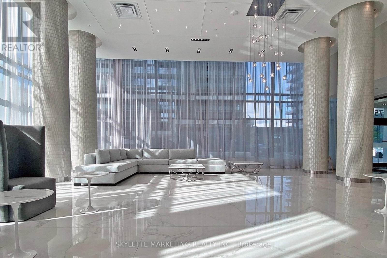 A modern living room with a large white sofa and a television.