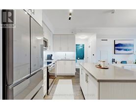 A modern kitchen with white cabinets and a stainless steel refrigerator.