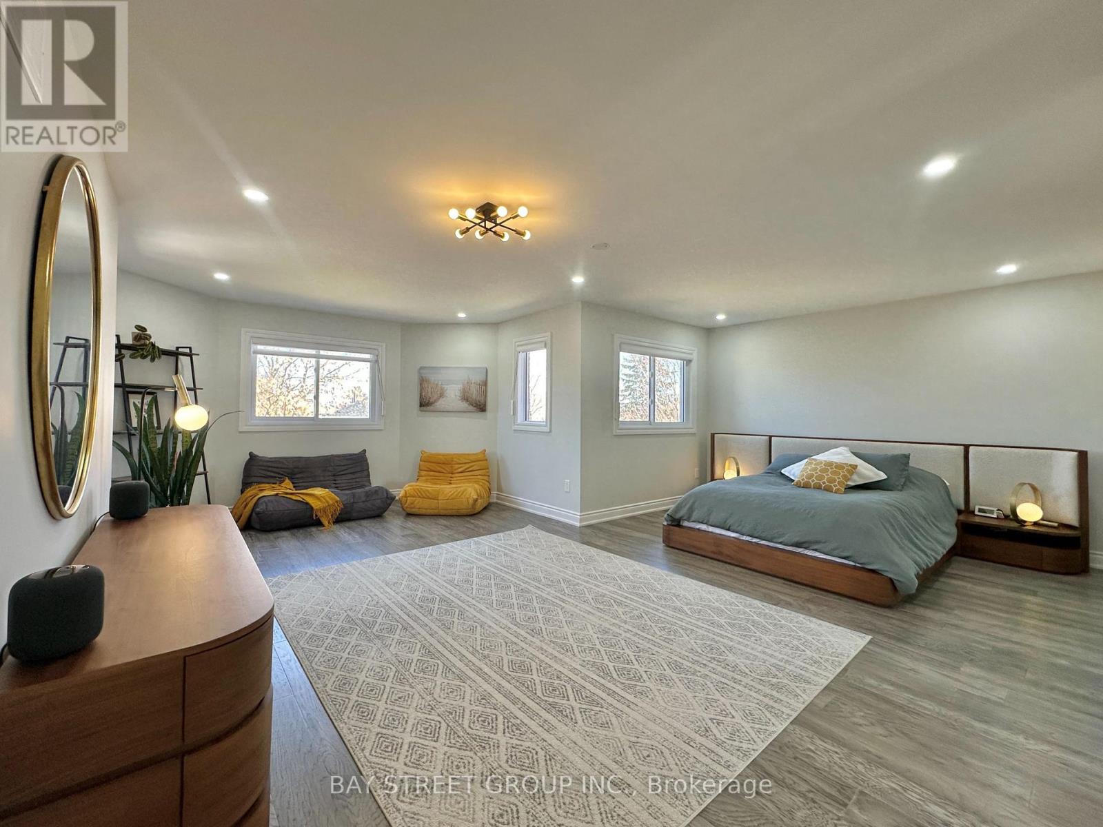 A bedroom with a large bed, a dresser, and a mirror.
