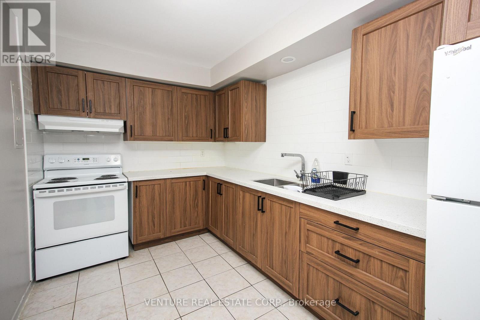 A kitchen with wooden cabinets and white appliances.