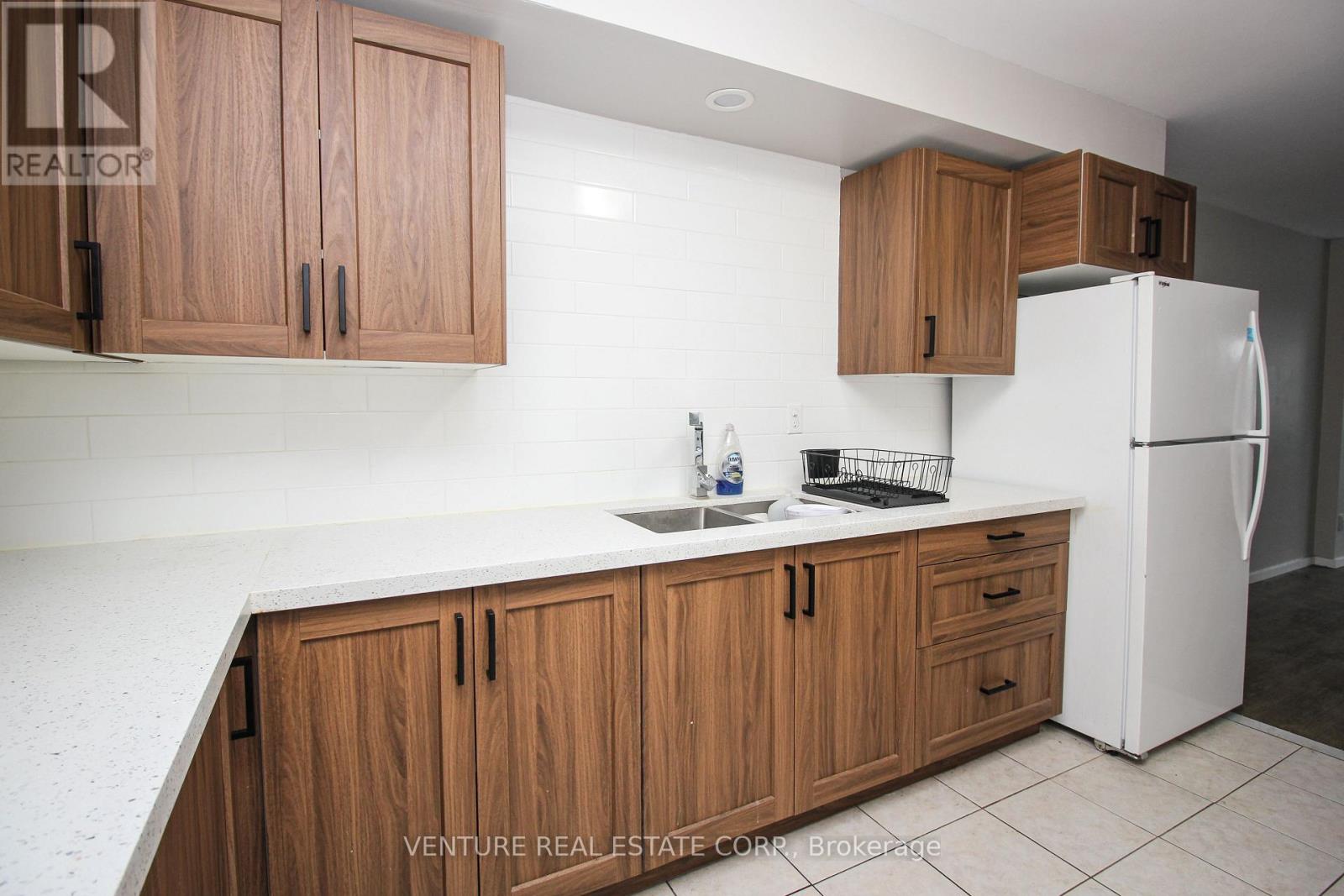 A kitchen with wooden cabinets and a white refrigerator.
