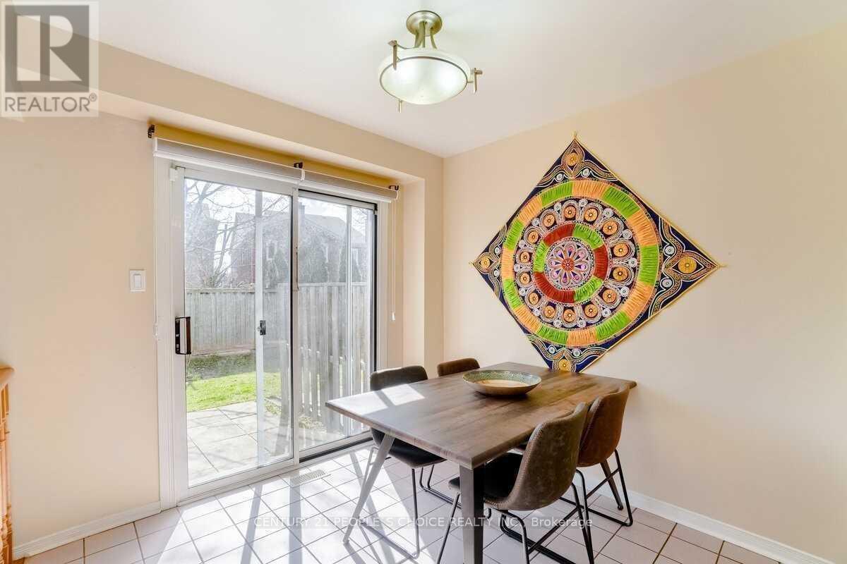 A dining room with a table and chairs and a large tapestry on the wall.