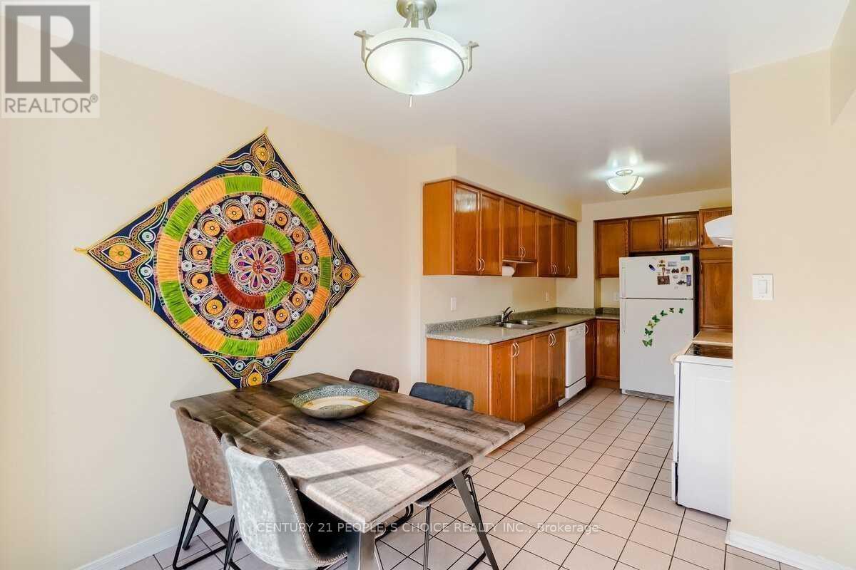 A kitchen with a table and chairs and a quilt hanging on the wall.
