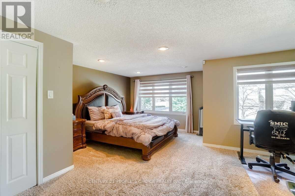 A bedroom with a large bed and a window with blinds.
