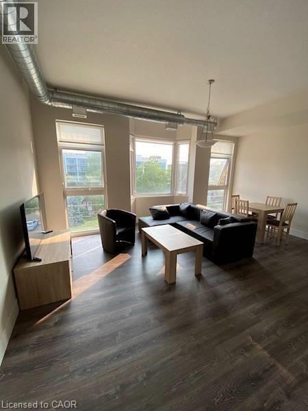 A living room with a black couch, a wooden coffee table, and a television.