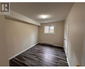 A room with a wooden floor and a window.