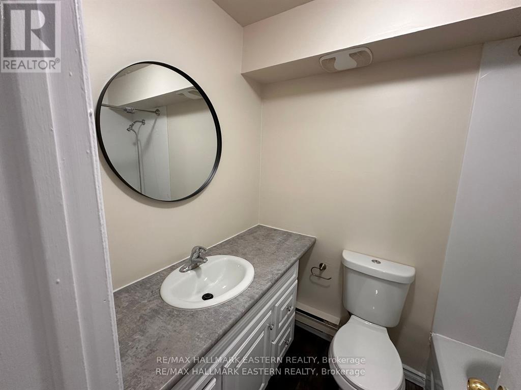 A bathroom with a toilet, sink and mirror.