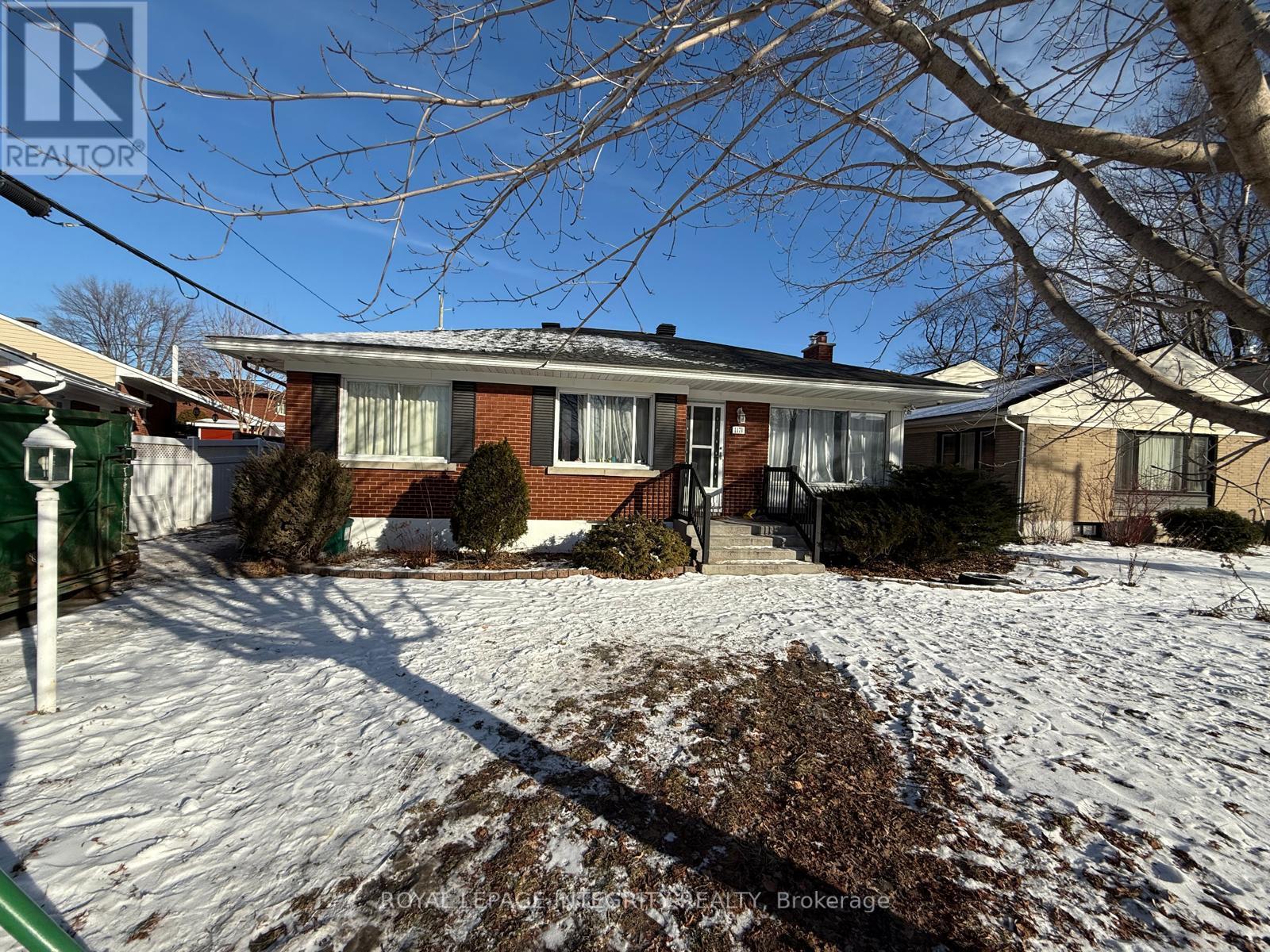 A house with a snow-covered ground in front of it.