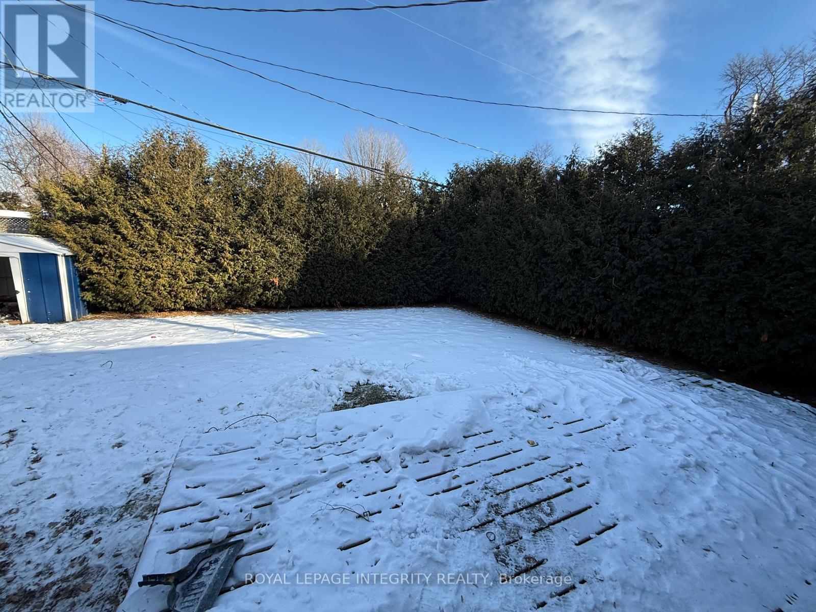 A snow-covered yard with a building in the background.
