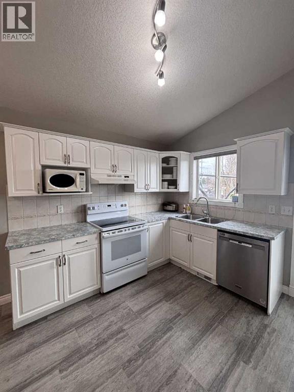 A kitchen with white cabinets and appliances.