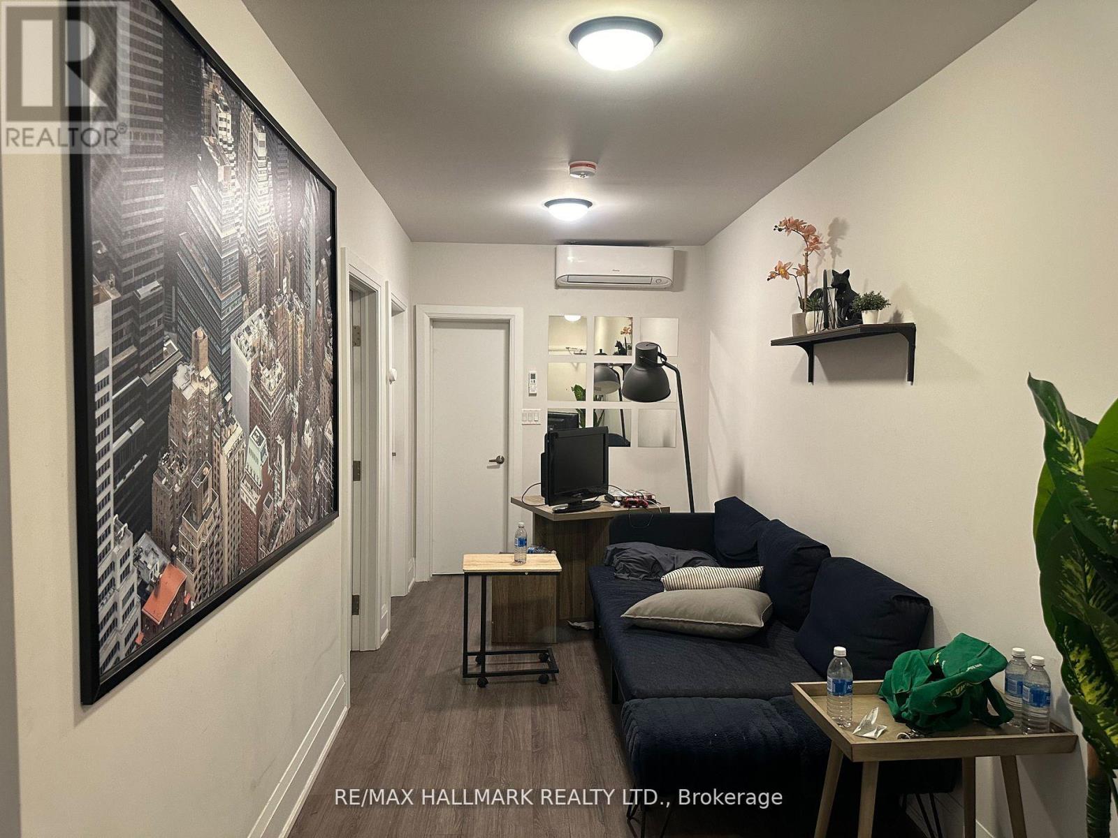 A living room with a couch, a table, and a painting on the wall.