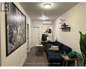 A living room with a couch, a table, and a painting on the wall.