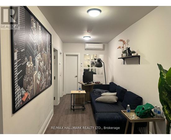 A living room with a couch, a table, and a painting on the wall.