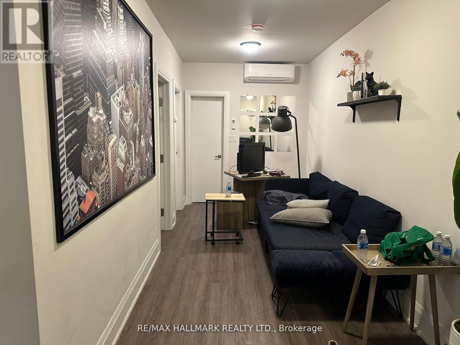 A hallway with a large painting on the wall and a couch with pillows.