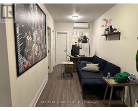 A hallway with a large painting on the wall and a couch with pillows.
