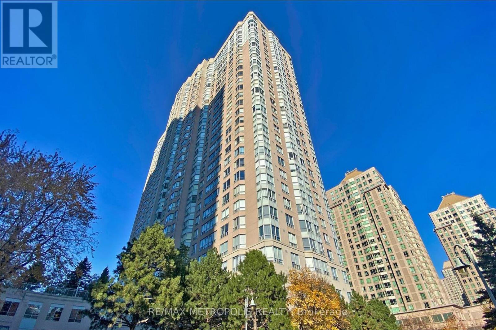 A tall residential building with a clear blue sky in the background.