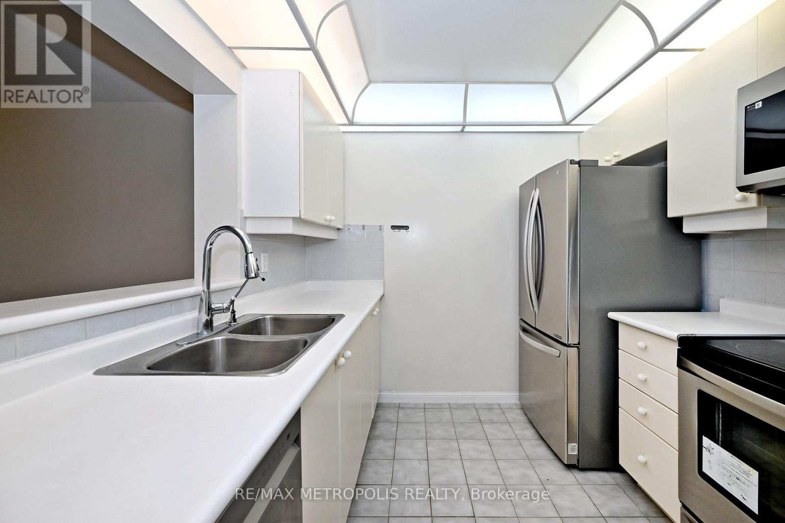 A modern kitchen with white cabinets and stainless steel appliances.