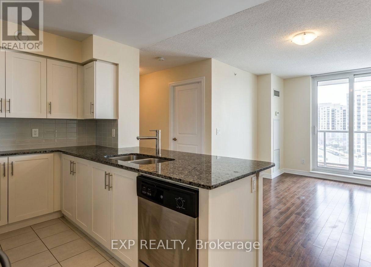 A kitchen with white cabinets and a black countertop.