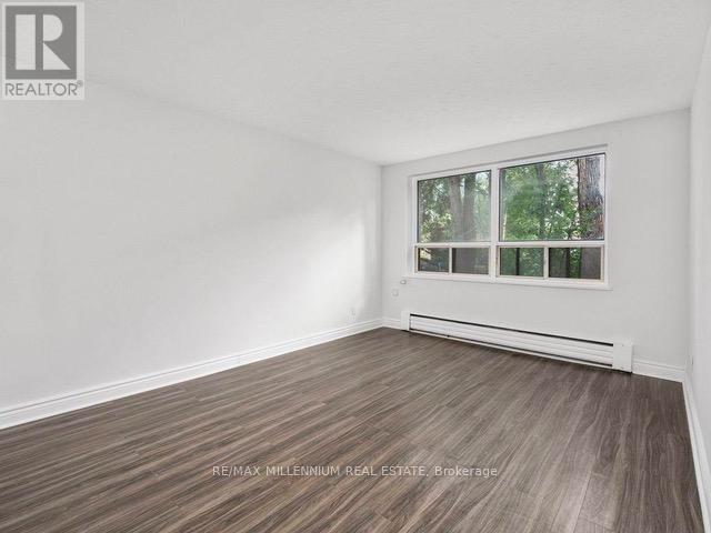 A room with a window and a wooden floor.