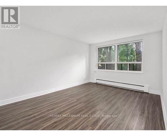 A room with a window and a wooden floor.