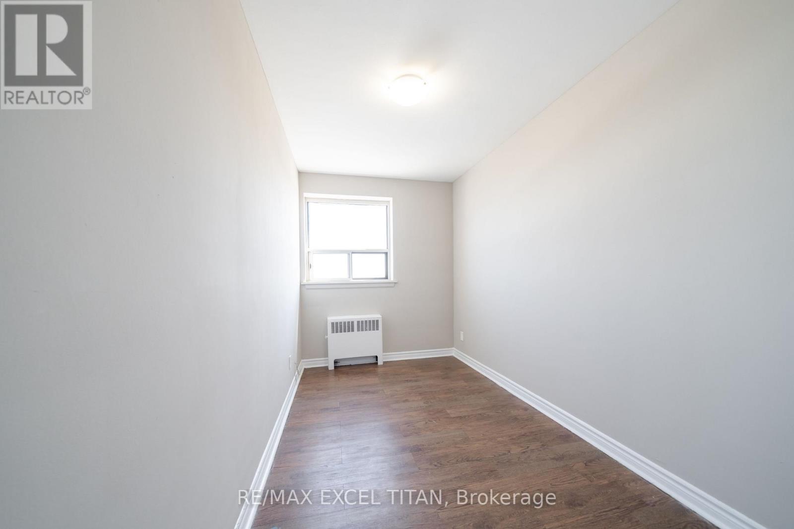 A white room with a window and a radiator.