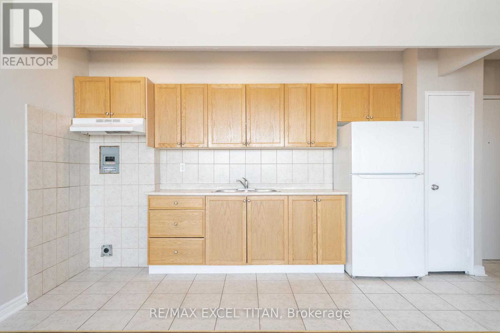 A kitchen with wooden cabinets and a white refrigerator.