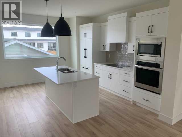 A kitchen with white cabinets and a large island.