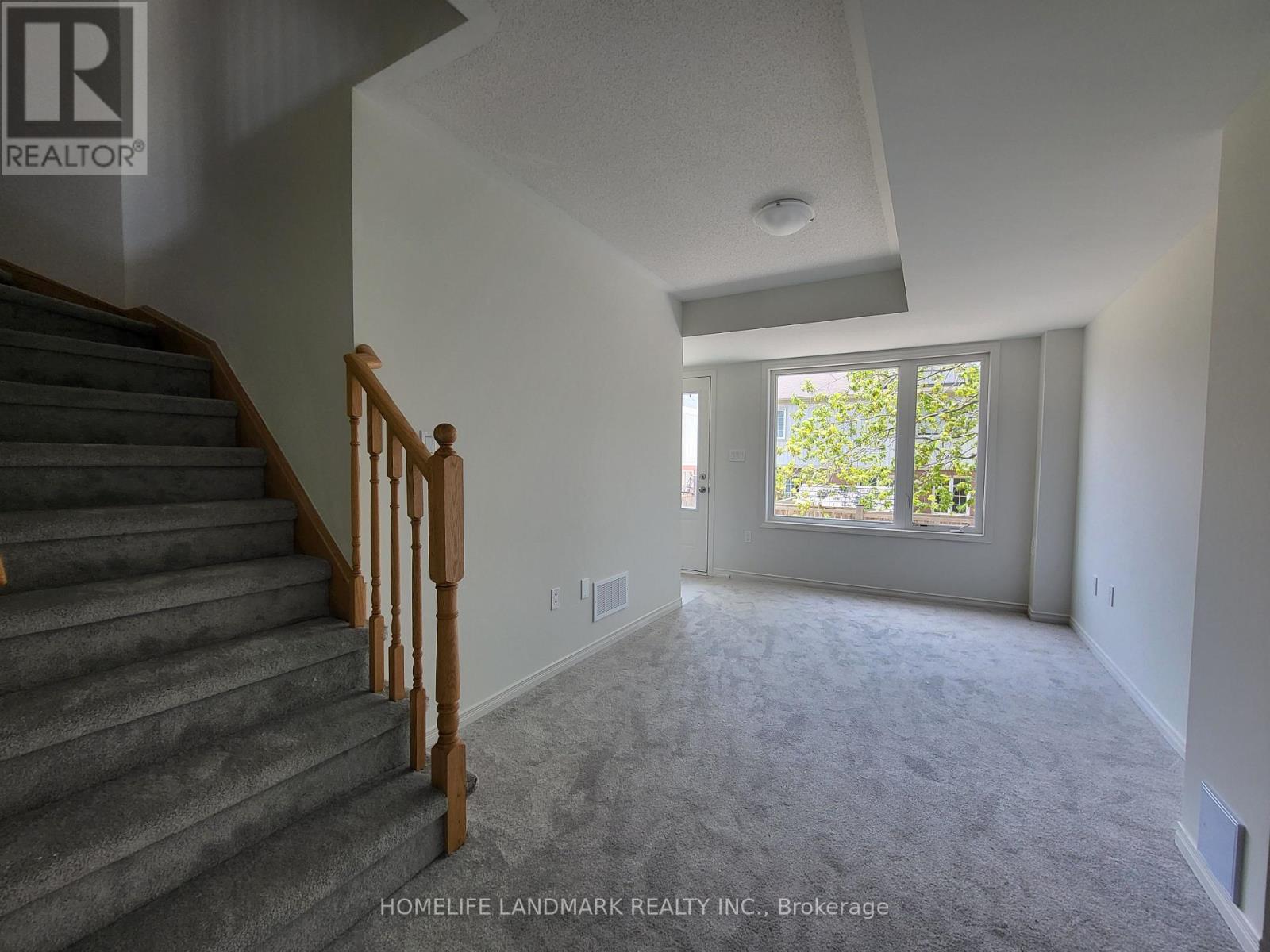 A spacious room with a staircase leading to the upper floor.