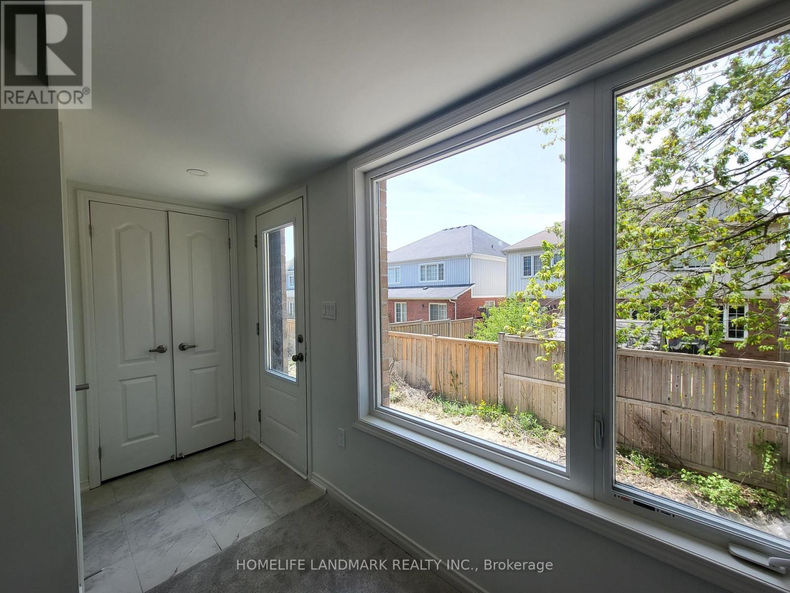 A room with a large window overlooking a backyard.