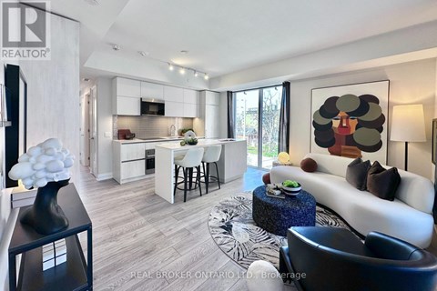 A modern living room with a white sofa and a large abstract painting on the wall.