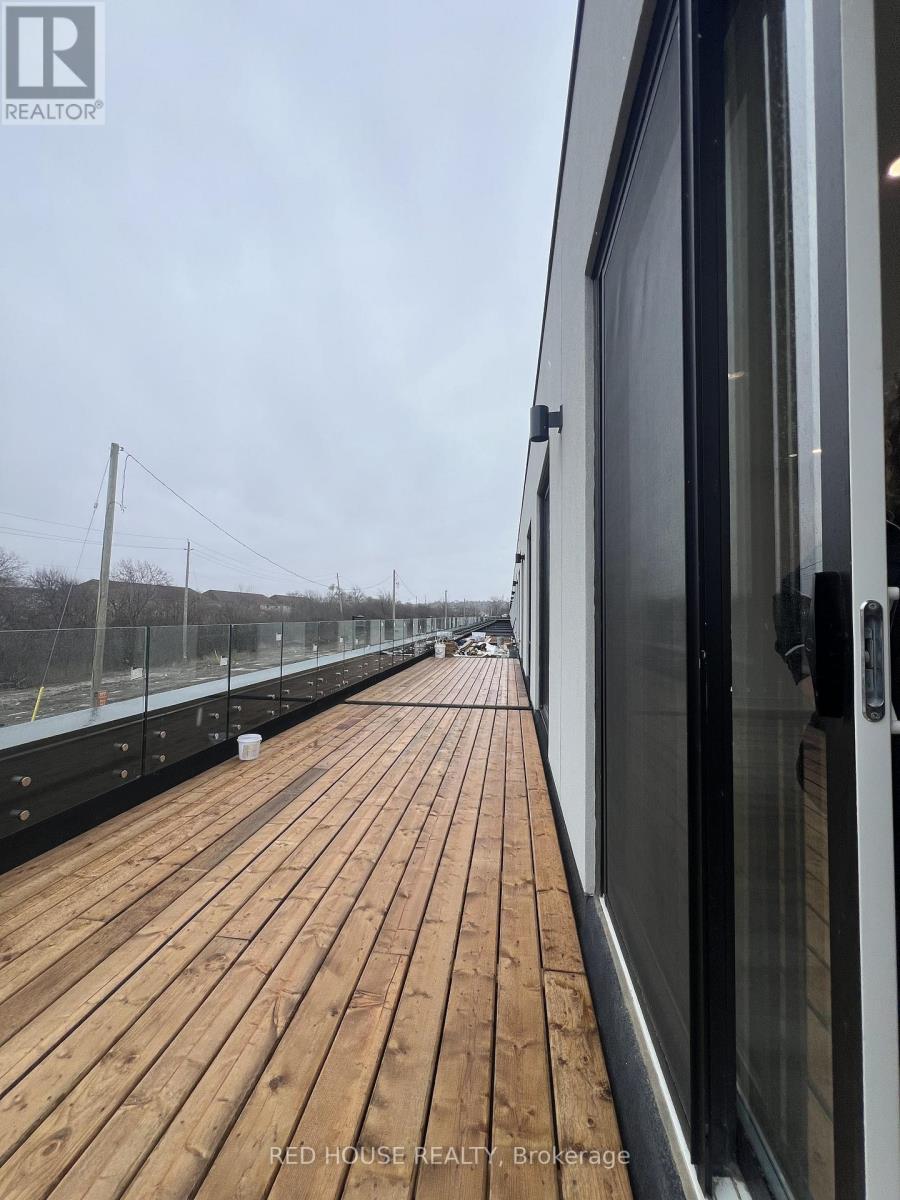 A wooden deck with a glass door on the right side.