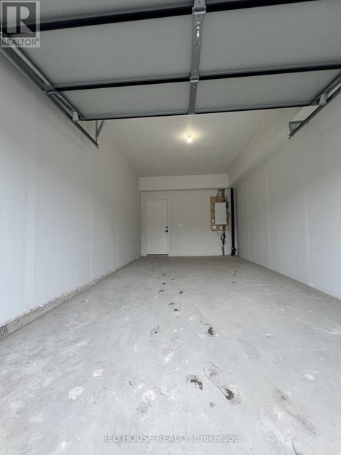A spacious empty room with a door in the middle and a pipe running along the wall.