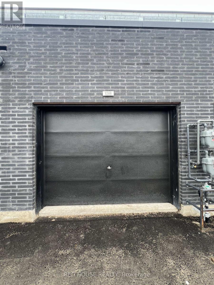 A large black garage door on a brick building.