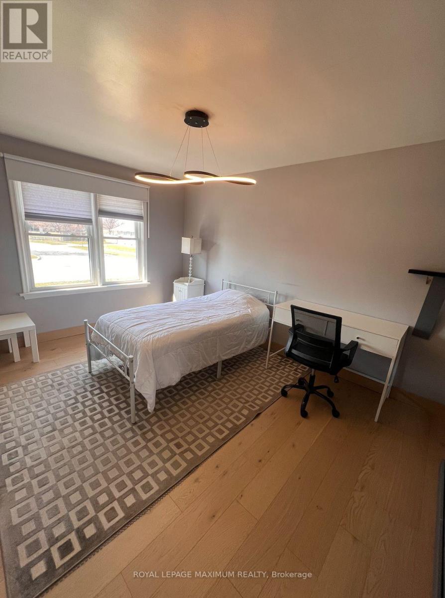 A bedroom with a bed, desk, and chair.