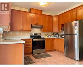 A kitchen with wooden cabinets and a stainless steel refrigerator.