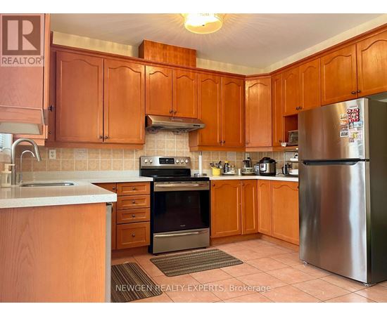 A kitchen with wooden cabinets and a stainless steel refrigerator.
