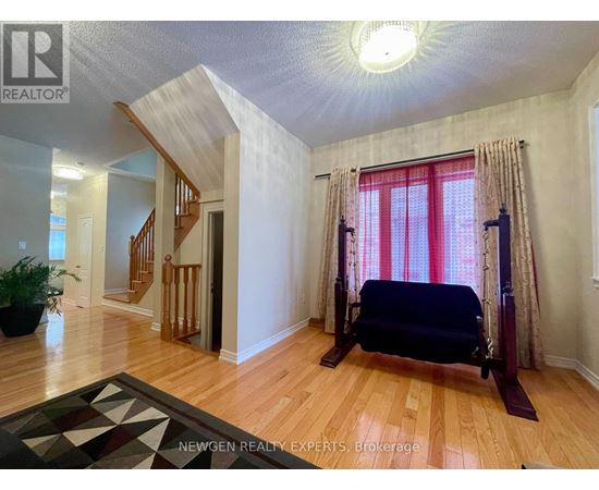 A bedroom with a bed, a window with curtains, and a rug on the floor.