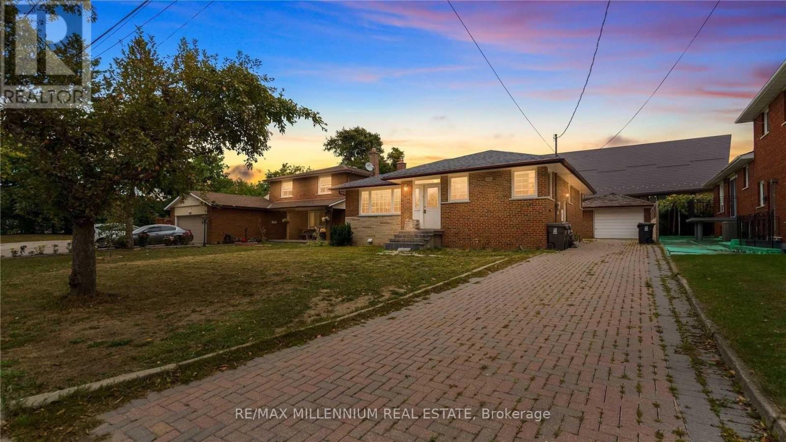 A house with a brick driveway is for sale.