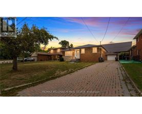 A house with a brick driveway is for sale.