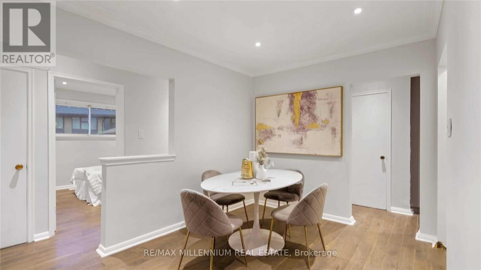 A dining room with a white table and chairs.