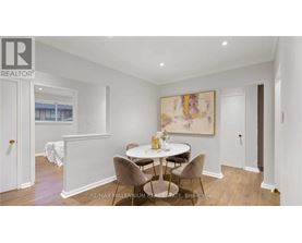 A dining room with a white table and chairs.