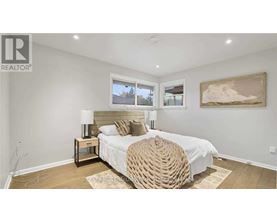 A bedroom with a large bed and a painting on the wall.
