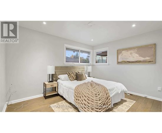 A bedroom with a large bed and a painting on the wall.