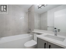 A white toilet sits next to a bathtub in a bathroom.