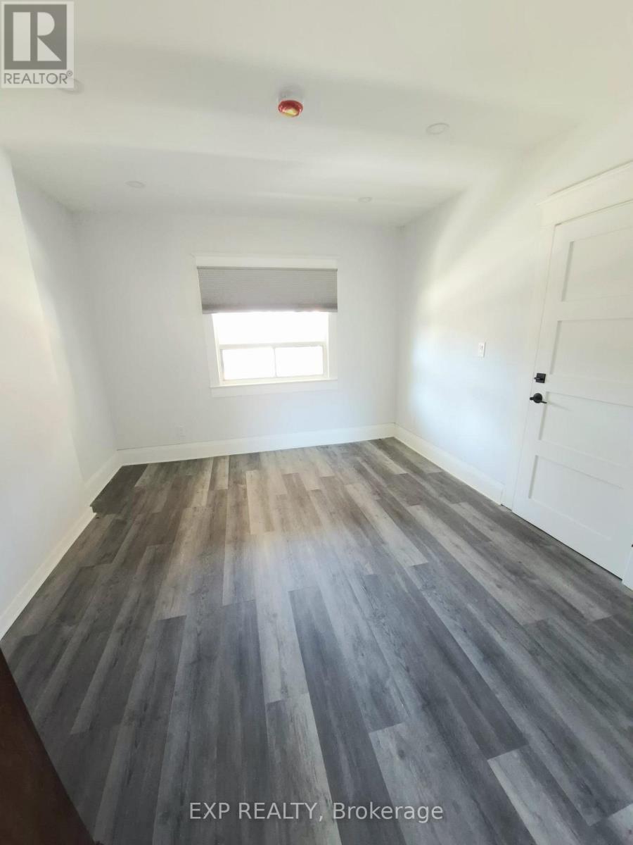 A room with wooden flooring and white walls.