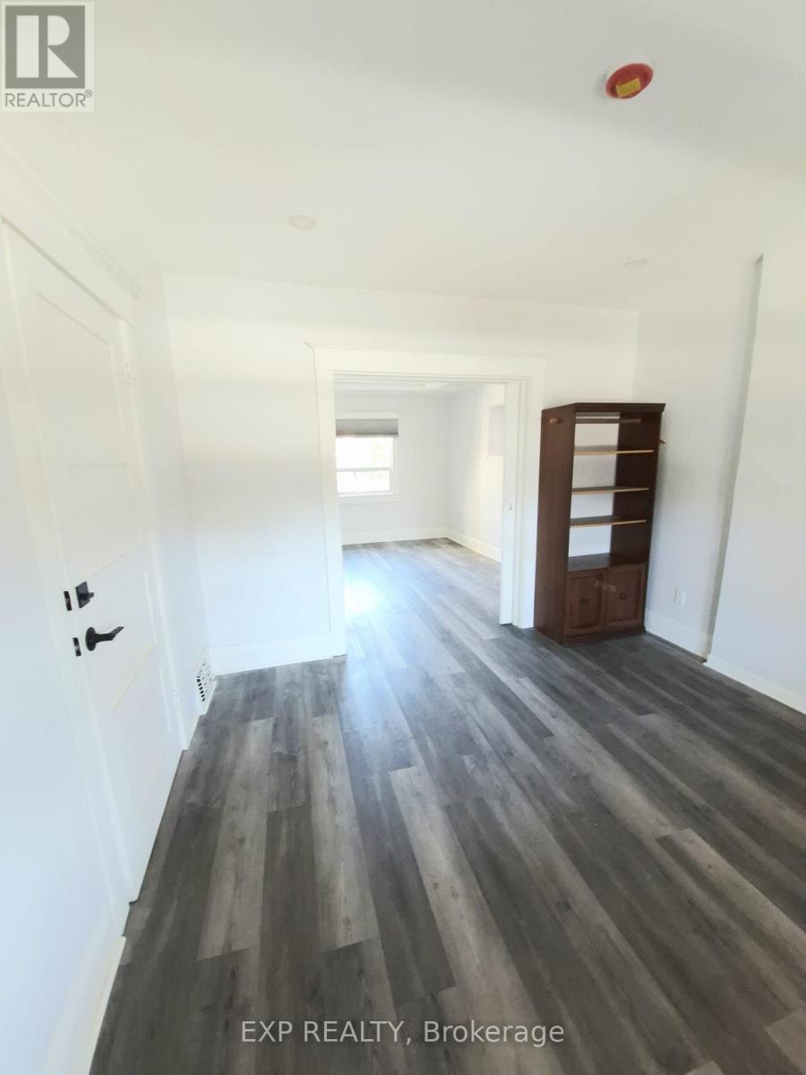 A long hallway with wood floors and white walls.
