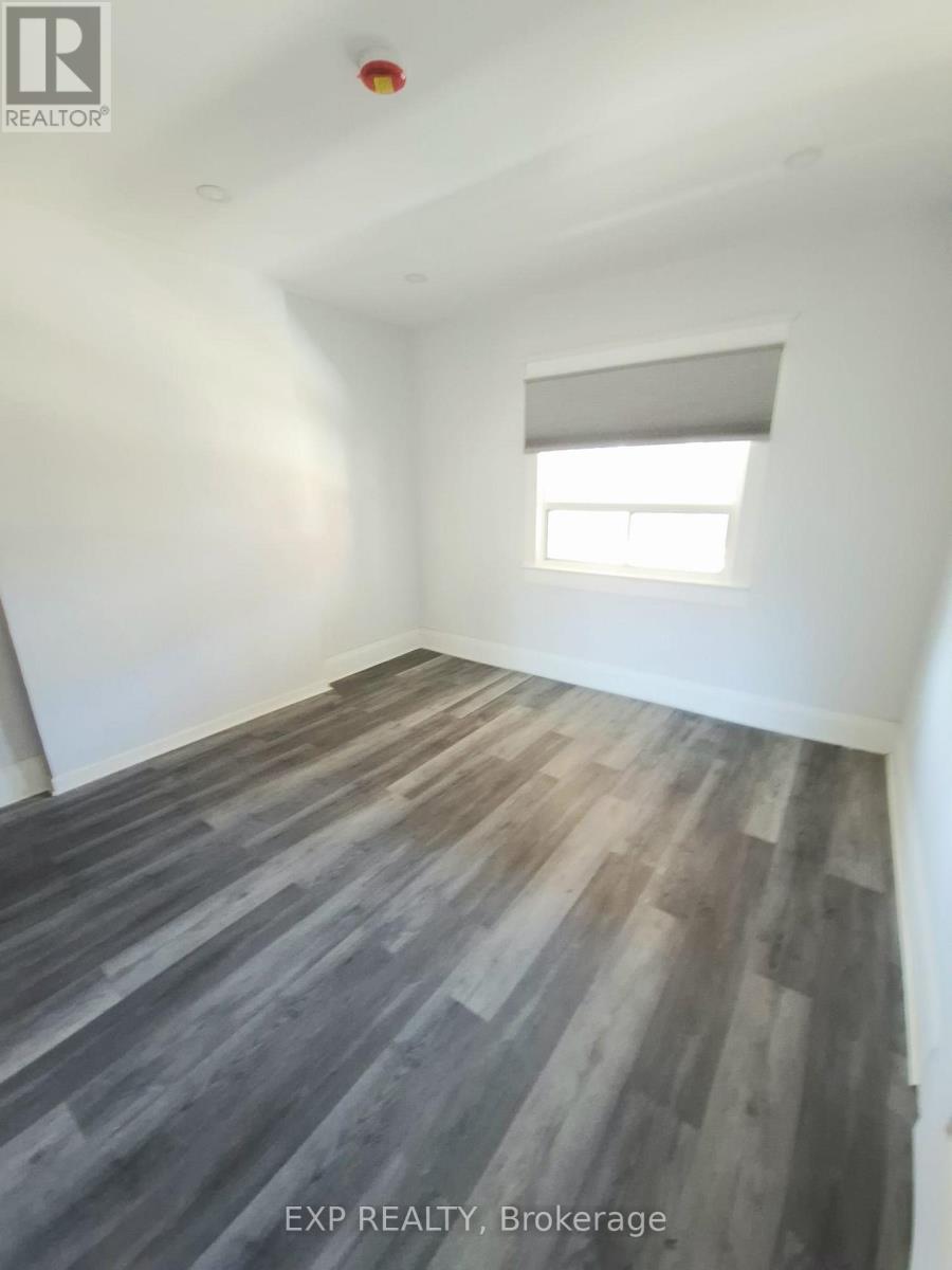 A room with wooden flooring and a window.