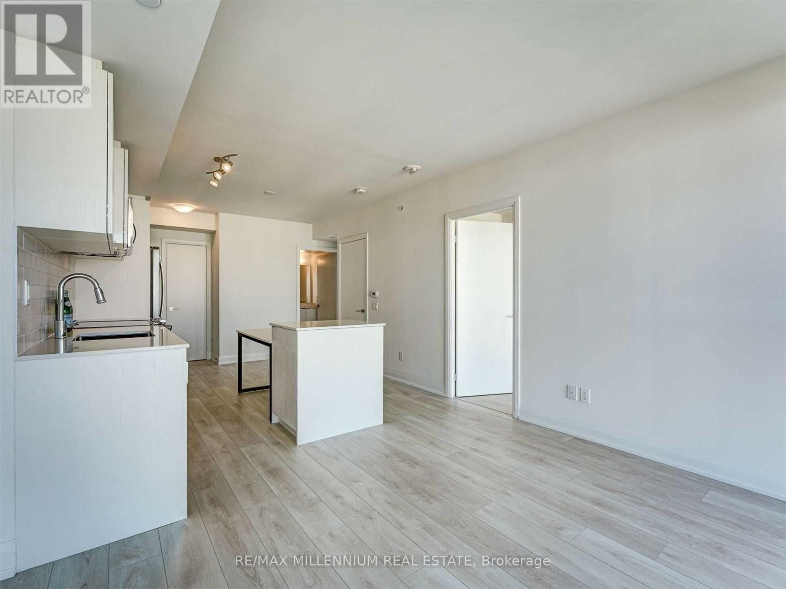 A spacious room with a kitchen area and a bar.