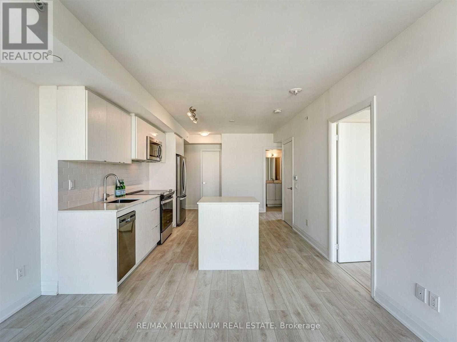A white kitchen with a white island in the middle.